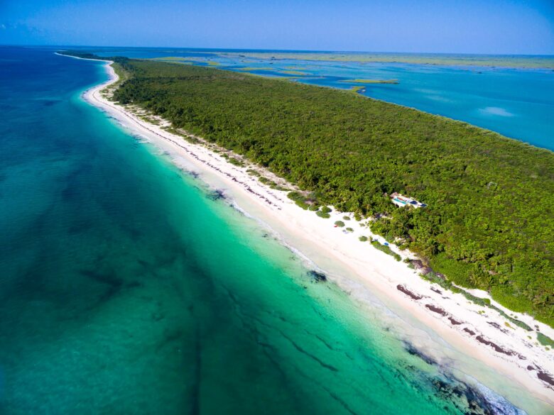 Aerial drone view of ANANA Hacienda Chekul, a private villa nestled in the lush jungle with stunning ocean and lagoon views in Tulum’s Sian Ka’an Reserve.